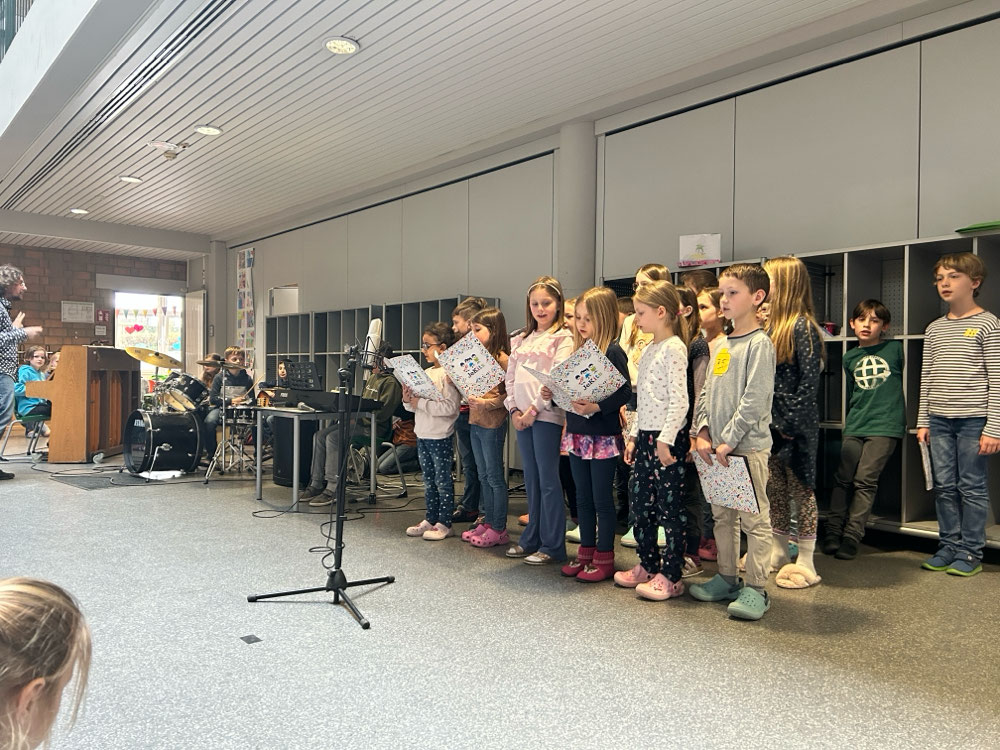 Der JeKits 2 Chor und die Schulband im Wochenabschluss